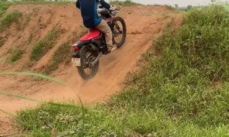 Honda CRF150L sedang melintasi medan tanah berlumpur