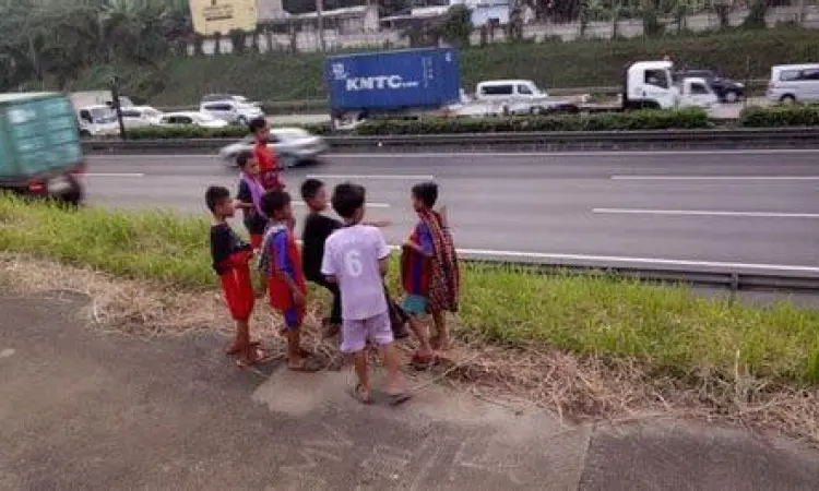 Budaya Om Telolet Om Anak-anak memegang papan bertuliskan Om Telolet Om