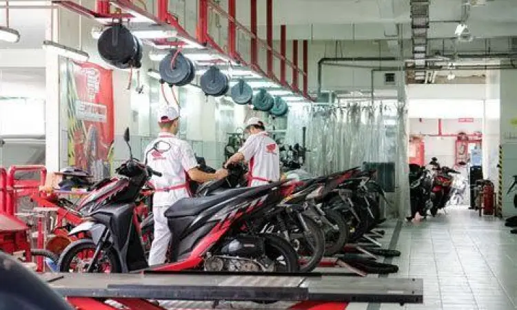 Mekanik sedang menservis Honda Beat FI
